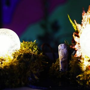 handmade dandelion resin lamp glowing in moss base